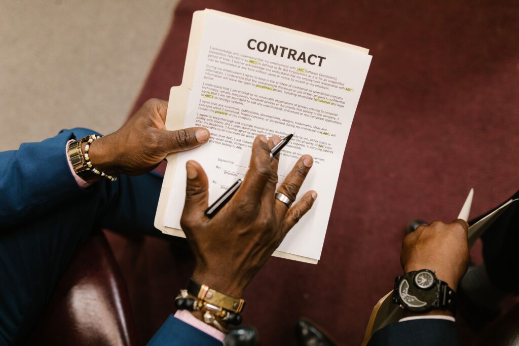 pexels photo 7841477 7841477 Two businessmen reviewing and signing a contract document in an office setting.